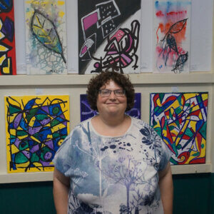 One of our residents in front of her art work at our 2024 AGM